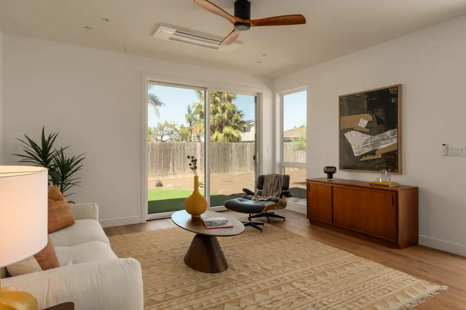 Sitting room with a mid-century sideboard, a lounge chair and sliding doors to the yard, Oceanside home