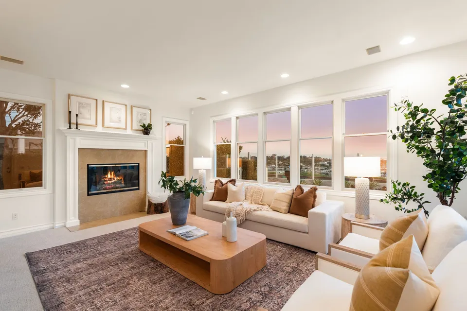 Living room with a fireplace and a wall of windows