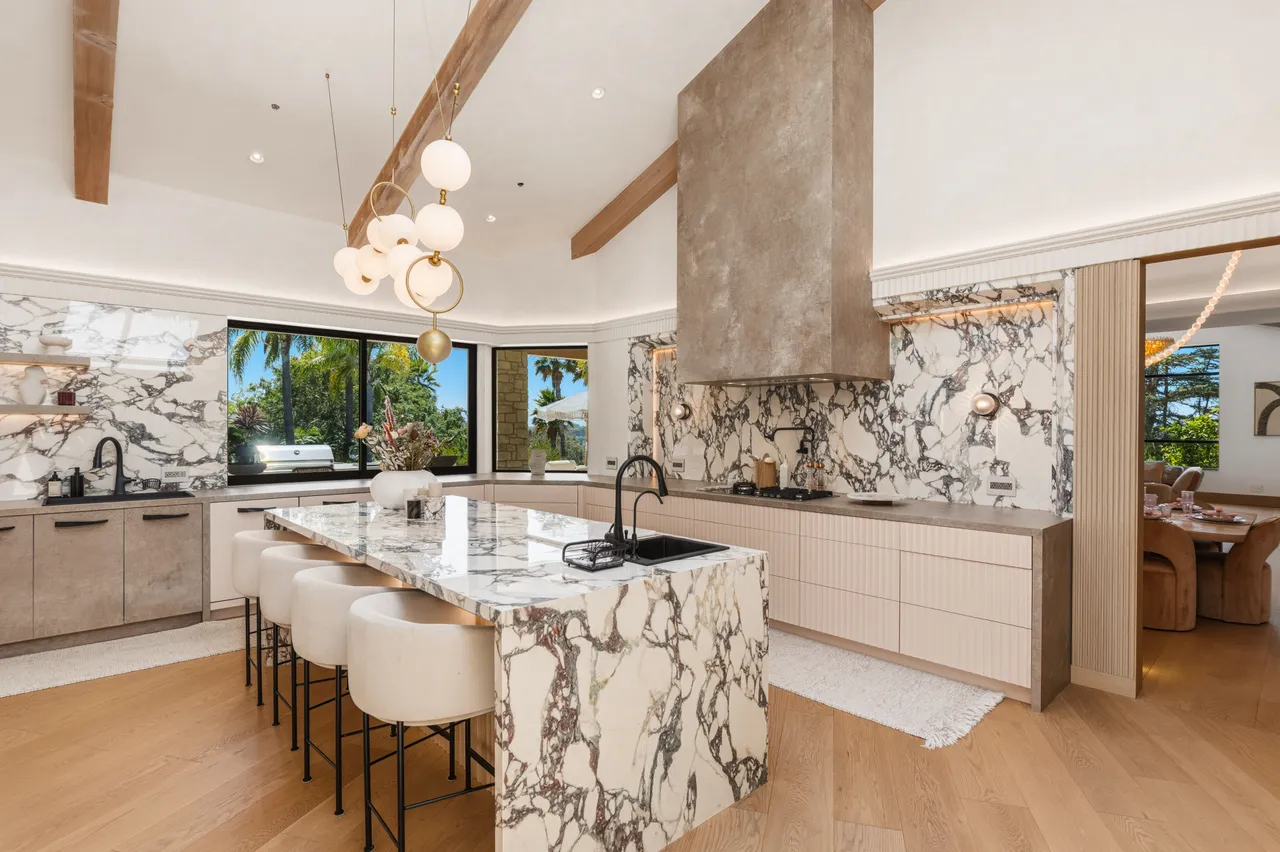 Kitchen with a marble island and a stone range hood
